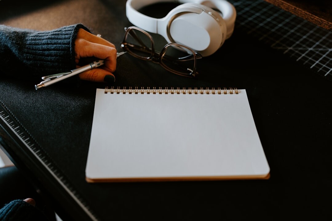 Journalist writing at desk with newspaper and notebook